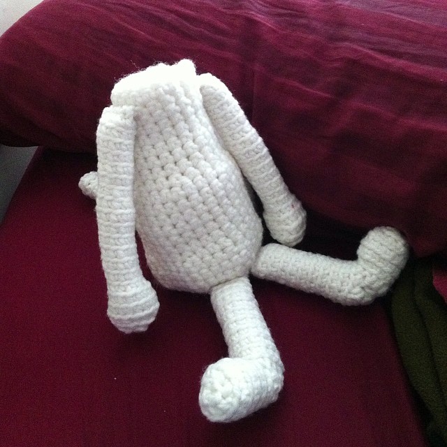 a crocheted bunny is laying down on a bed