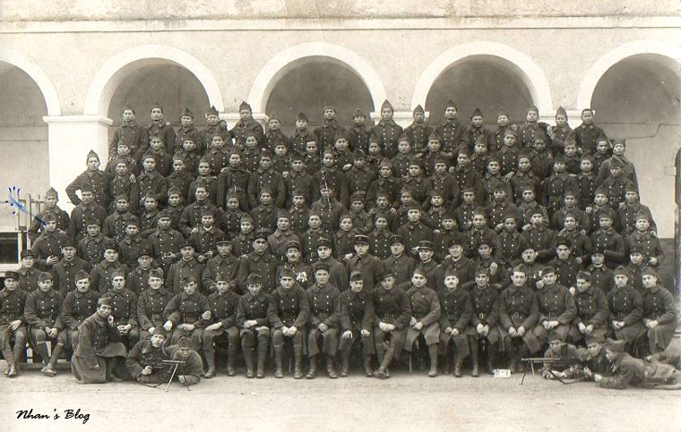 black and white pograph of military men sitting in front of arches