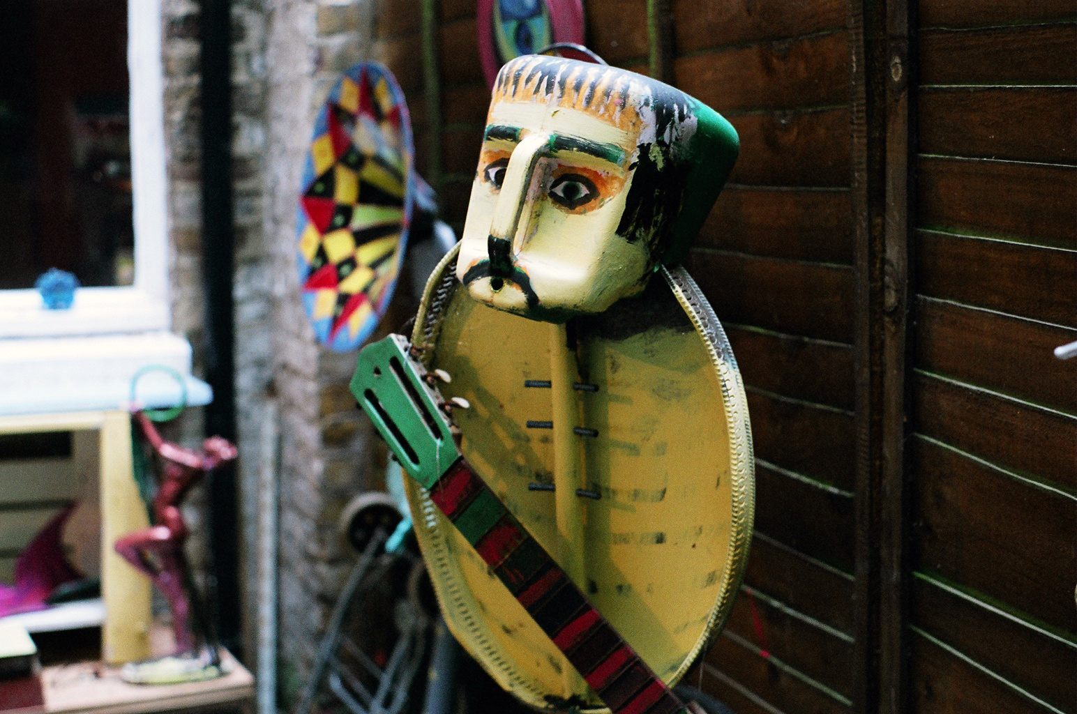 a mask hanging up on a wall next to a building