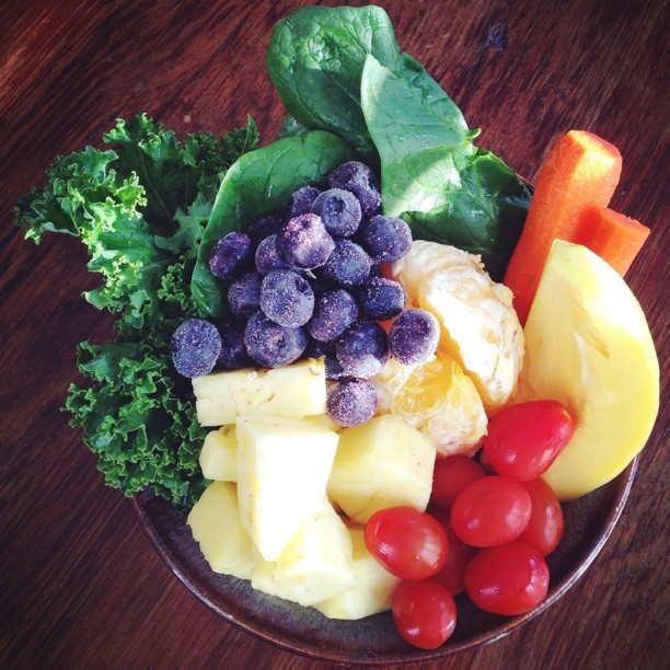 a bowl of fresh fruits, vegetables, and greens