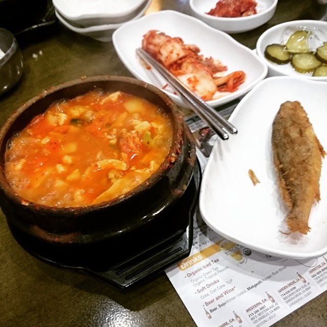 a table covered with white dishes and bowls full of different foods