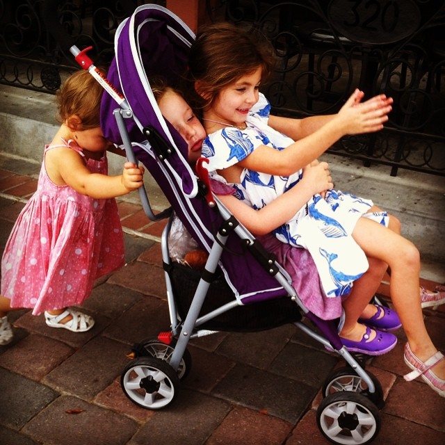the two children are sitting on the stroller