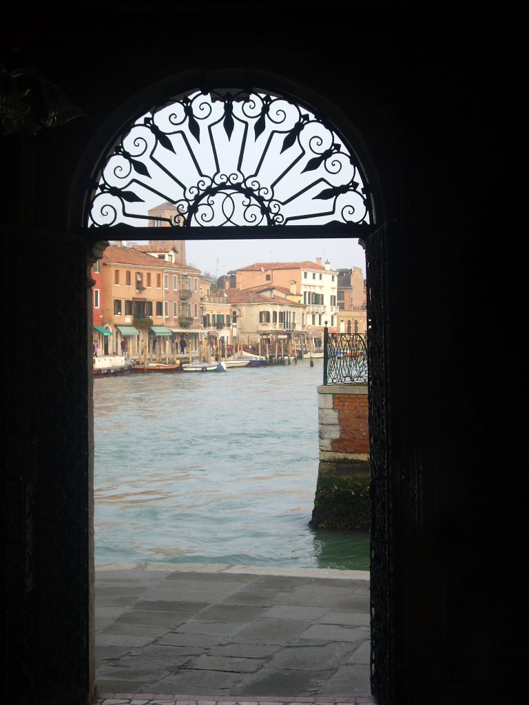 view through arched windows at a river passing under a bridge