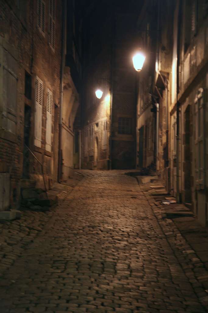 an empty street is shown with two lights at night