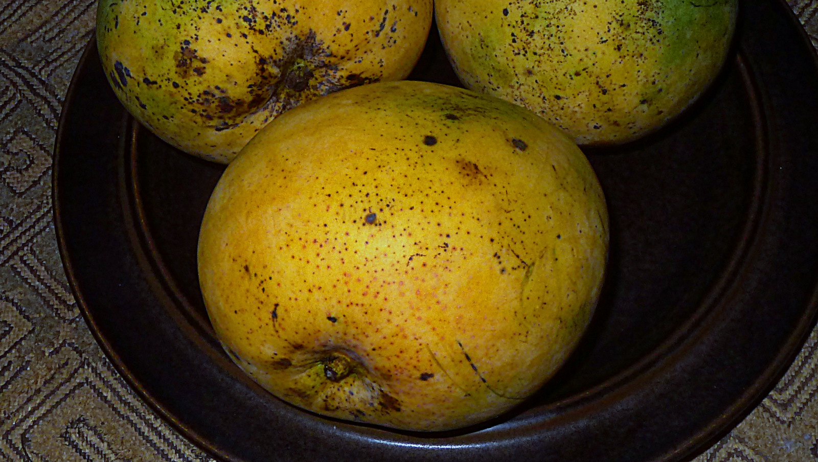 three pears sit atop each other in a bowl