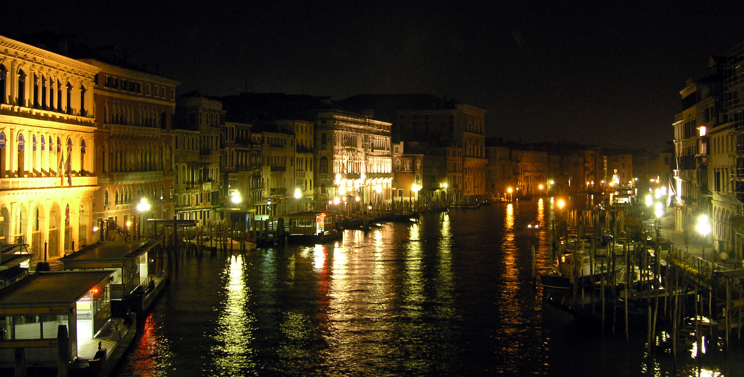 a street is lit up and along the water