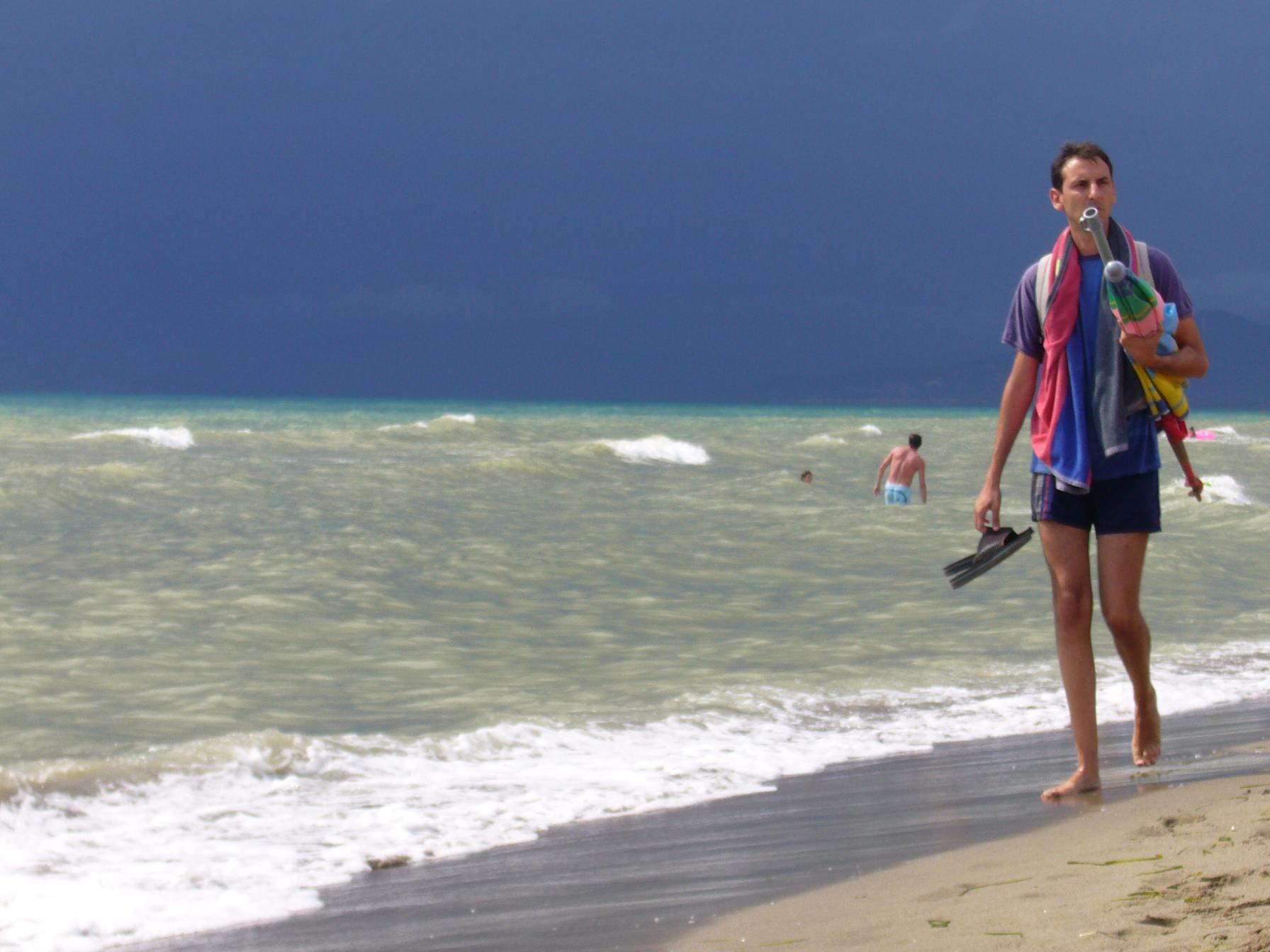 a woman is walking down a beach next to the water