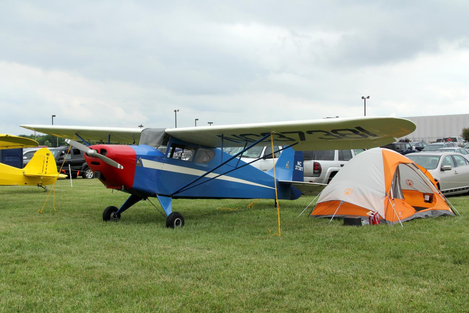 a small airplane is parked next to some tents