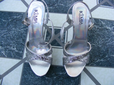 the feet of a pair of silver high heeled shoes
