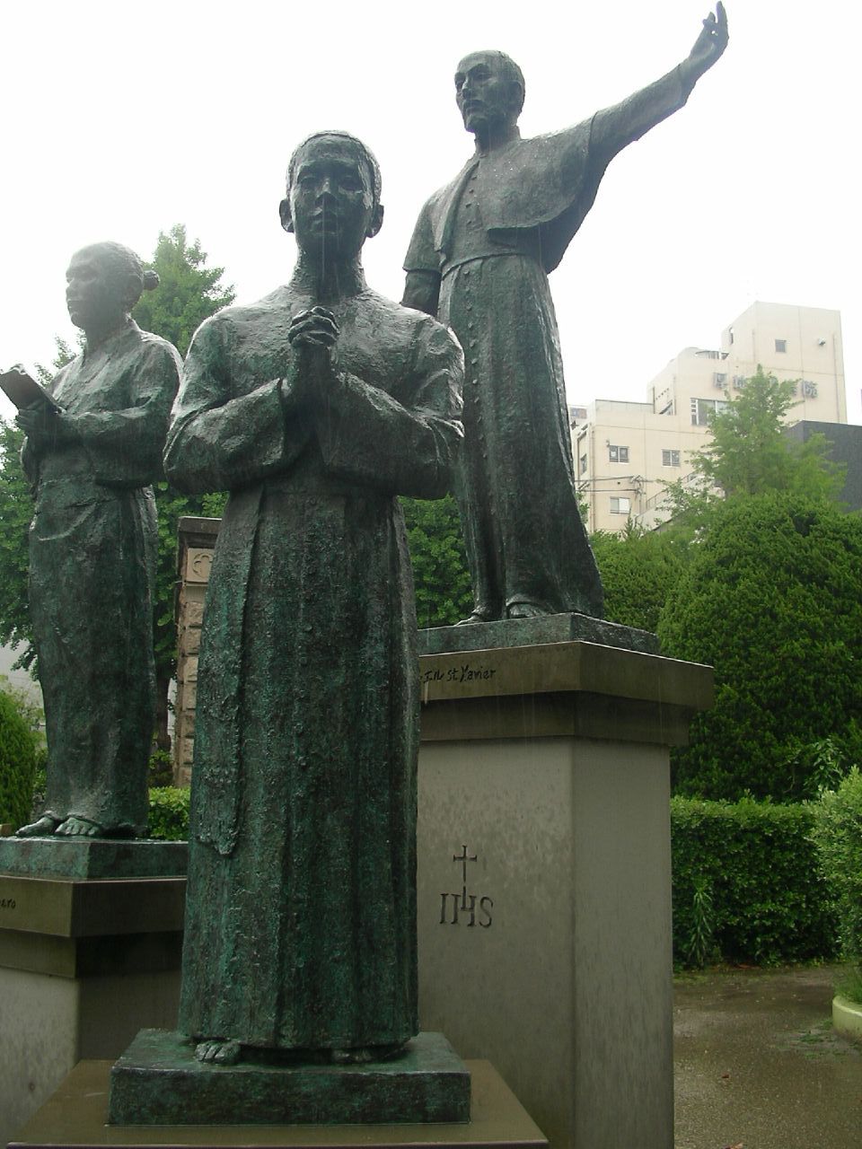 two statues of men with arms outstretched in front of a large building