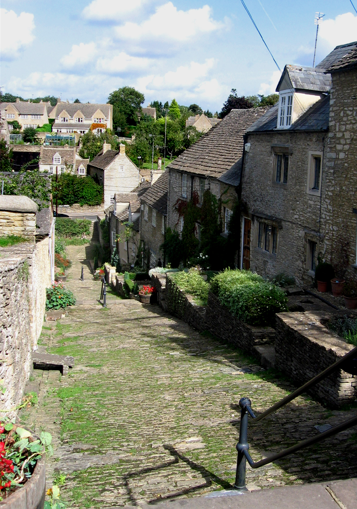 a stone - built building with an overhang in the countryside