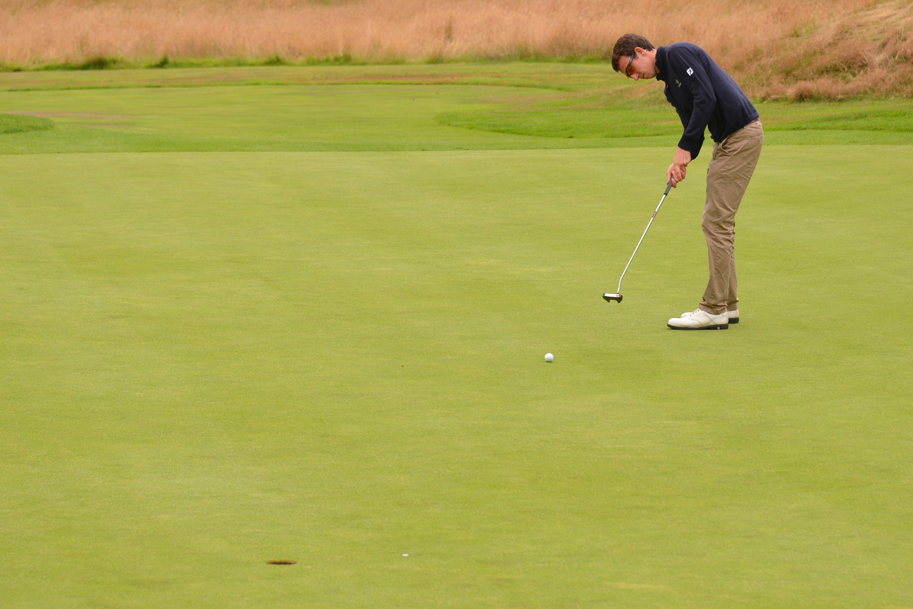 a man on a golf course preparing to make a s