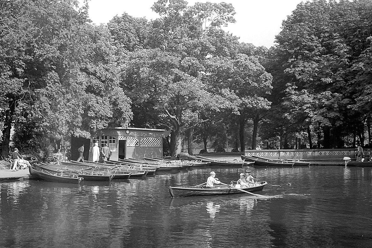 men are rowing their boats through a lake