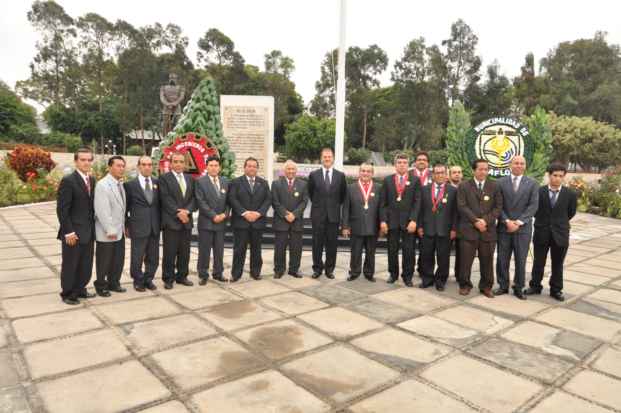 men in suits standing on a sidewalk in front of a monument