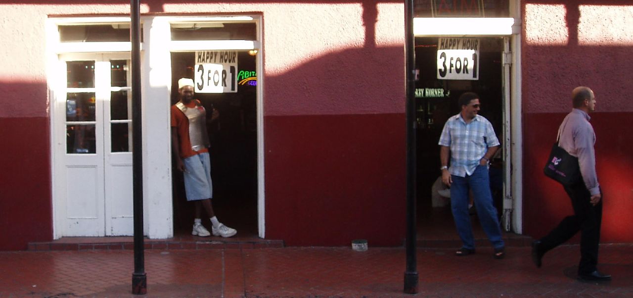 three people standing outside a store, some with bags