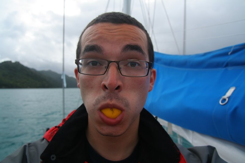 a man in glasses holding an orange peel to his mouth