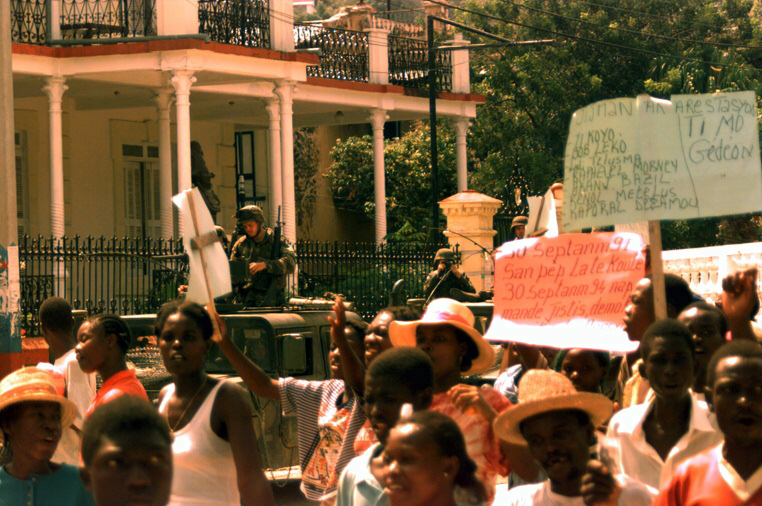a group of people holding signs in front of a house