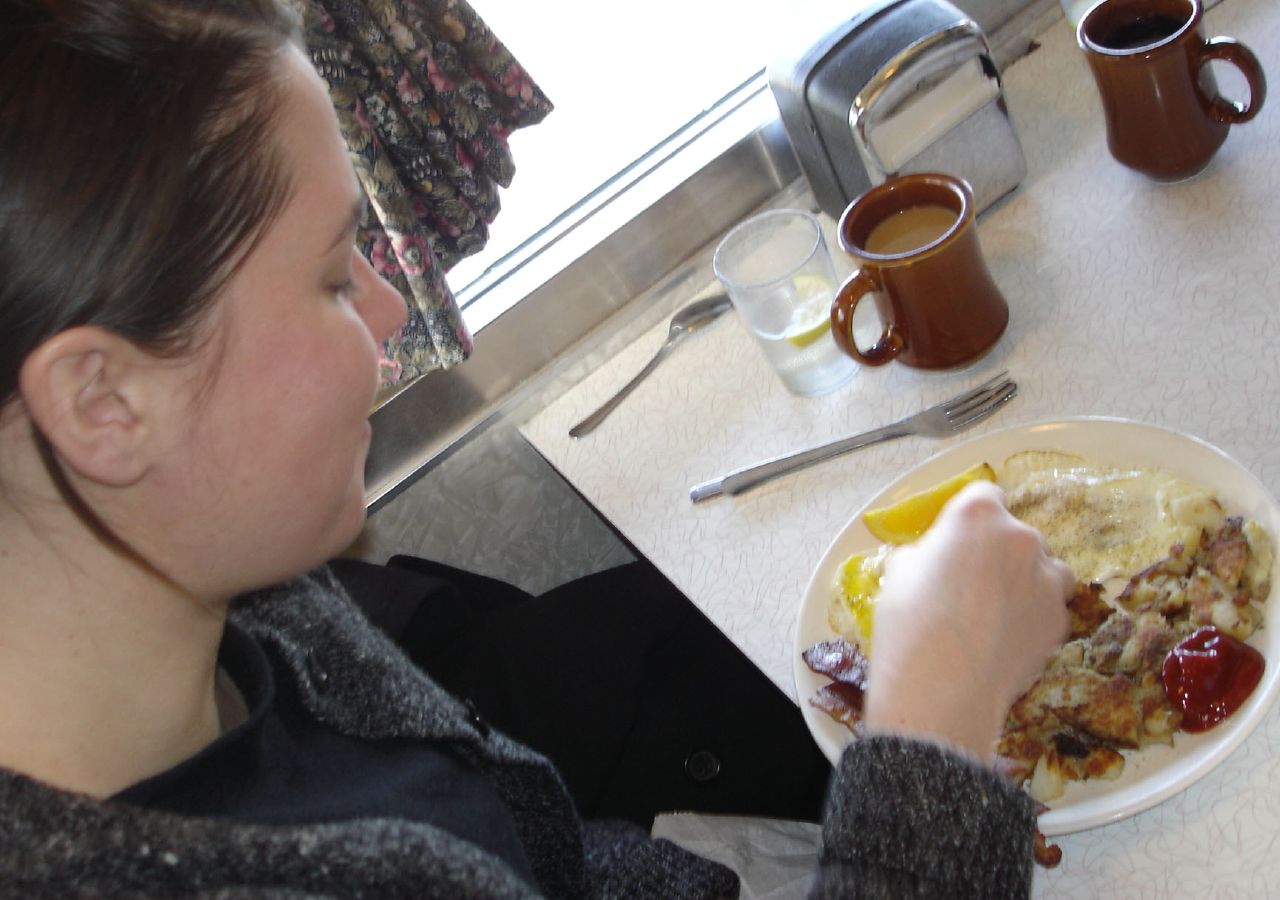 a person sitting at a table with a plate of food