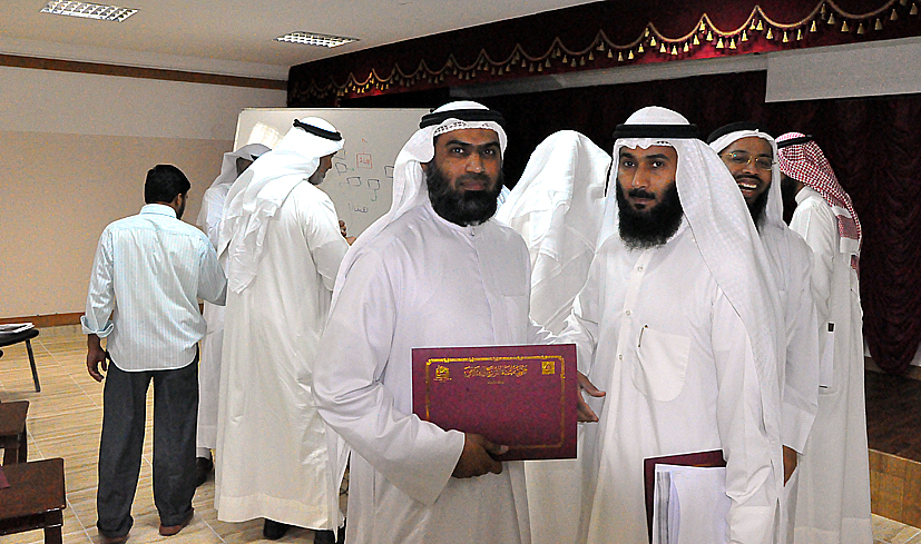 several men dressed in white holding an arabic book