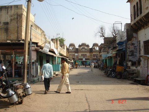 two men walk down an old run down city street