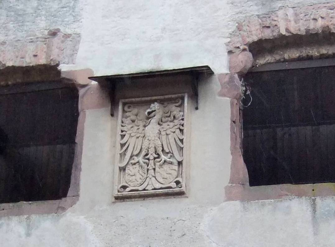 an ornate window sill on a white stucco wall