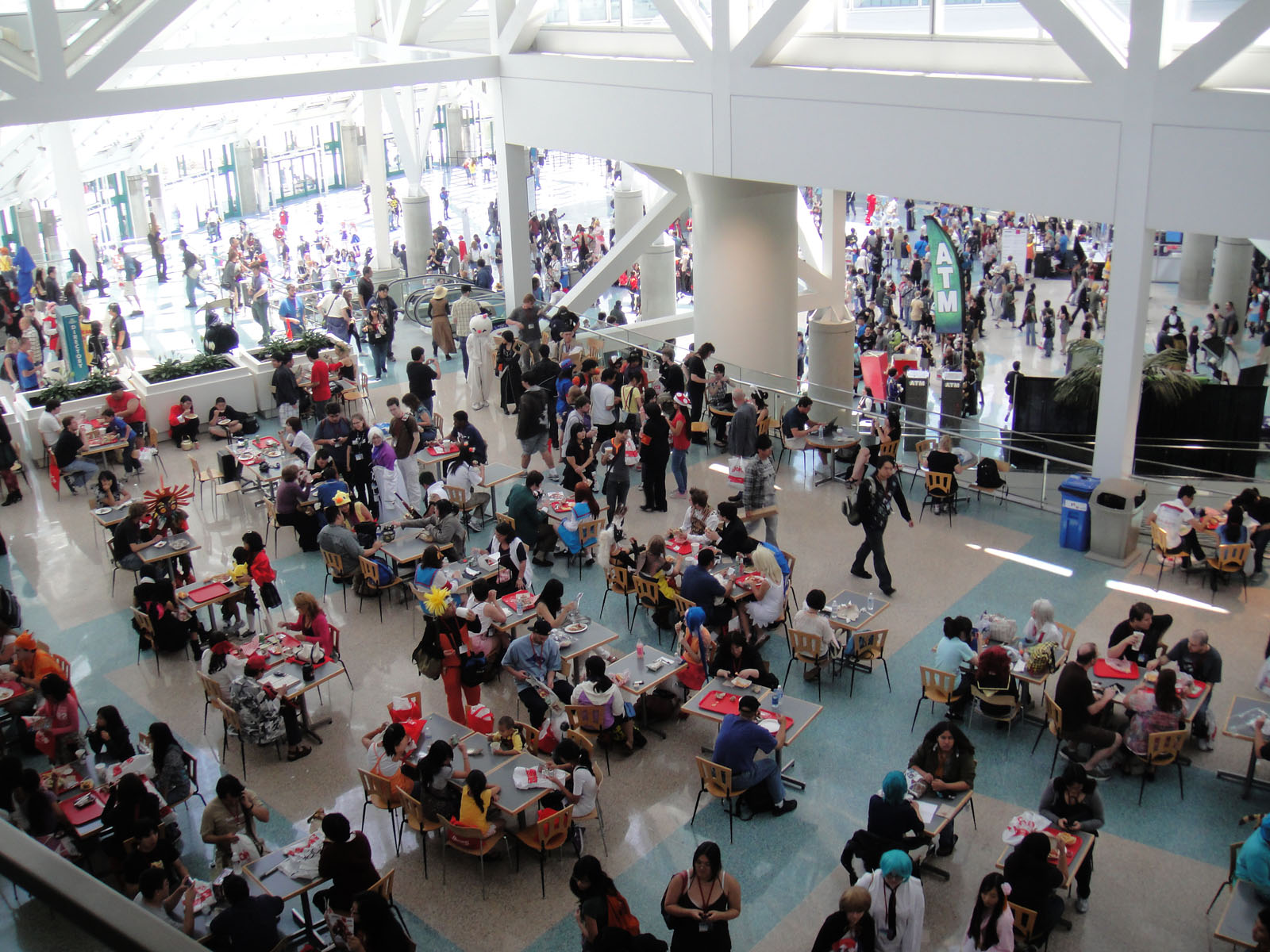 a crowded airport lobby with tables and chairs