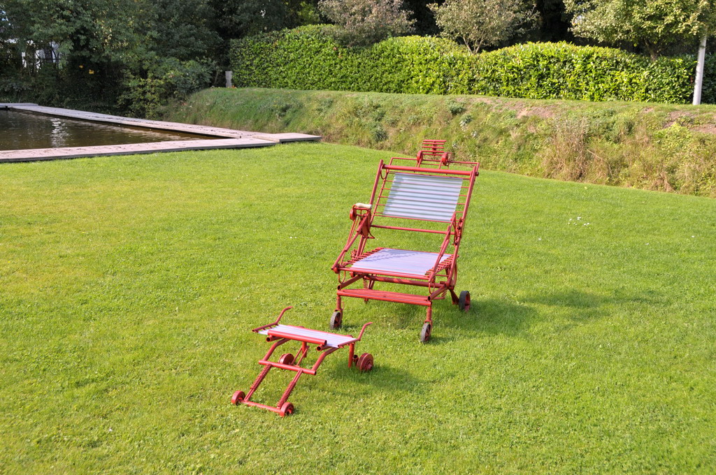 two lawn chairs and a bench in the grass
