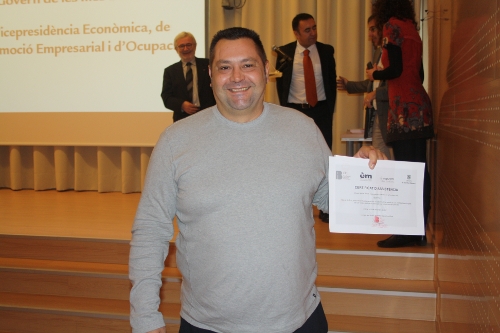 a man is posing with a large certificate in his hand