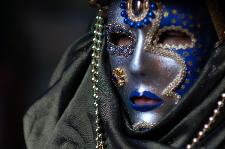 a person with a blue mask and necklace