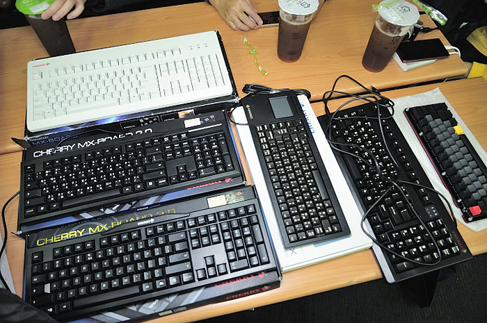 two laptops are lined up on a desk, with some keyboard keys on one side