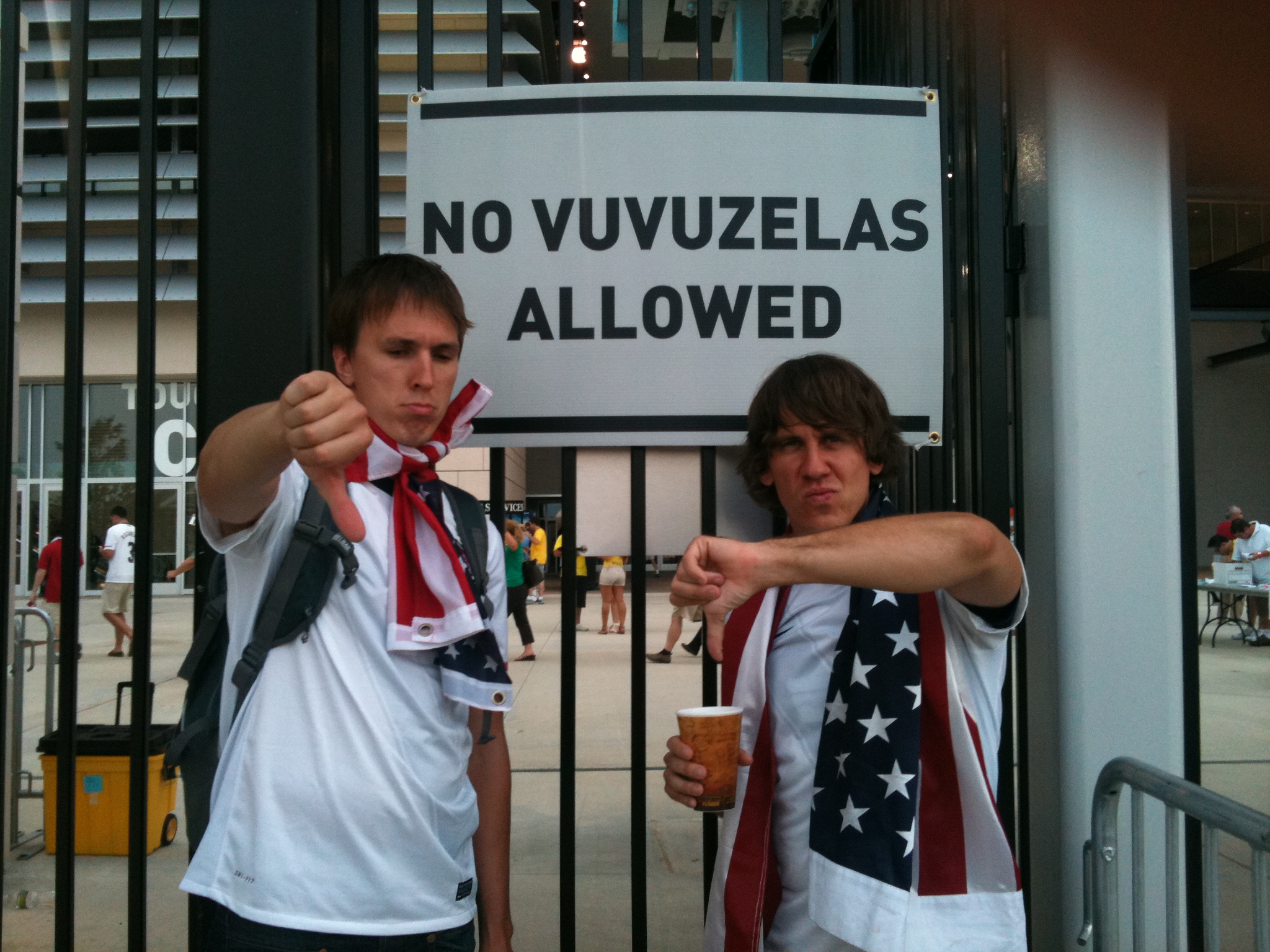 two guys holding drinks giving thumbs up