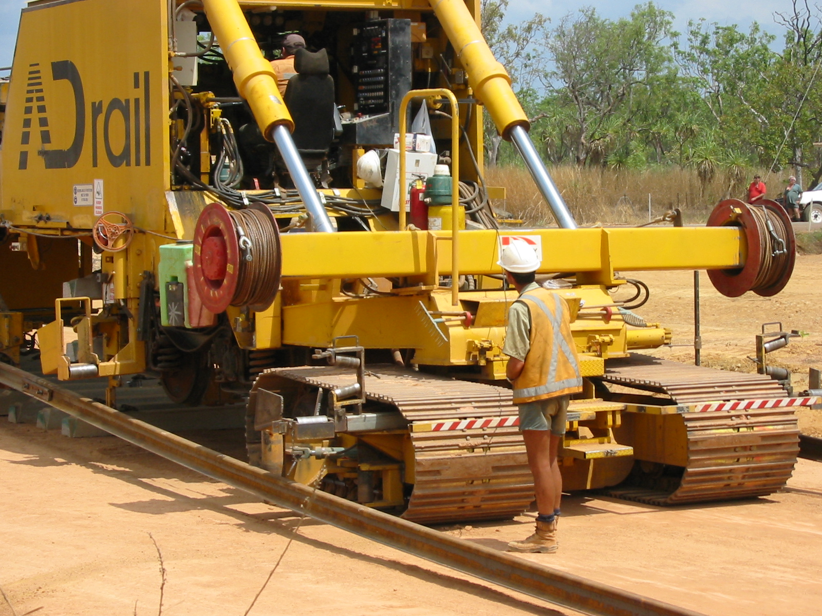 a large yellow machine is parked on train tracks