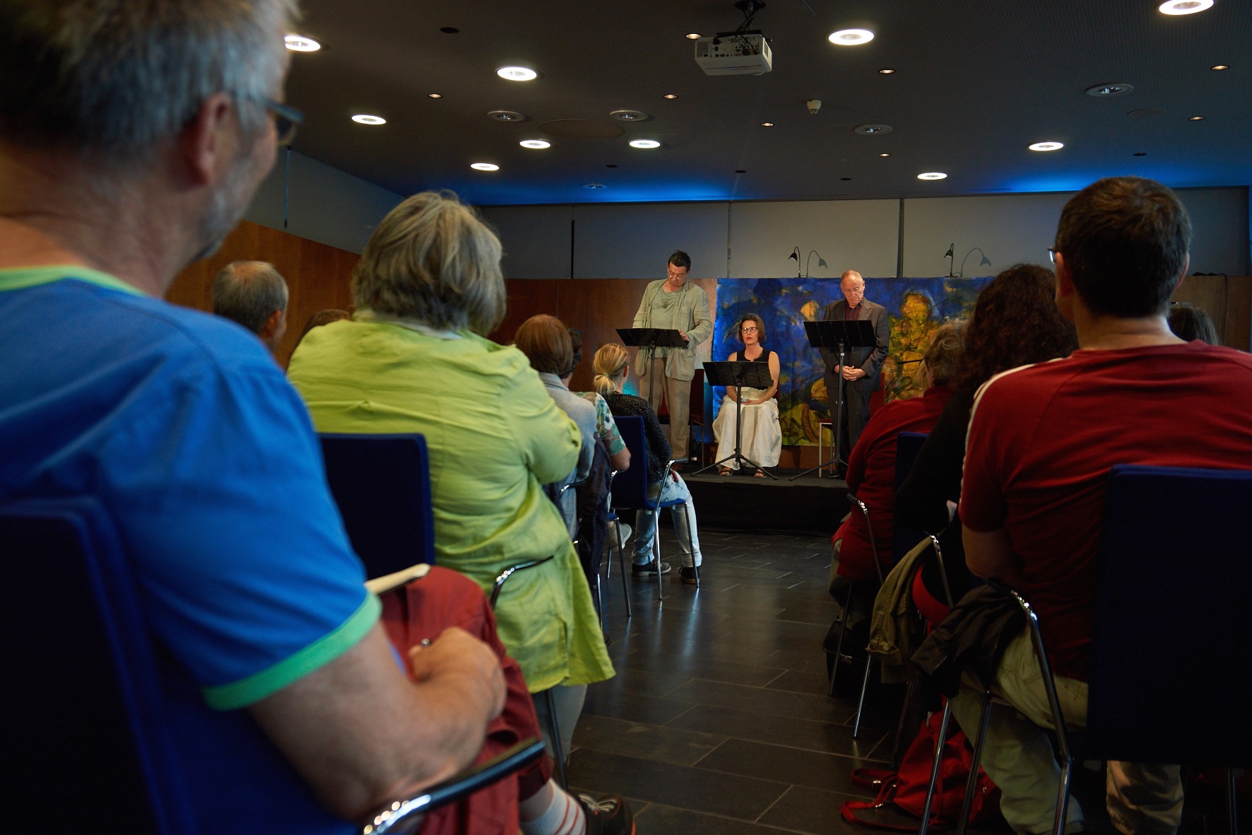 a small gathering on stage with some people sitting