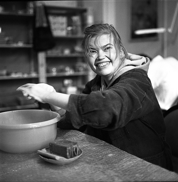 a woman holding up her neck near a bowl
