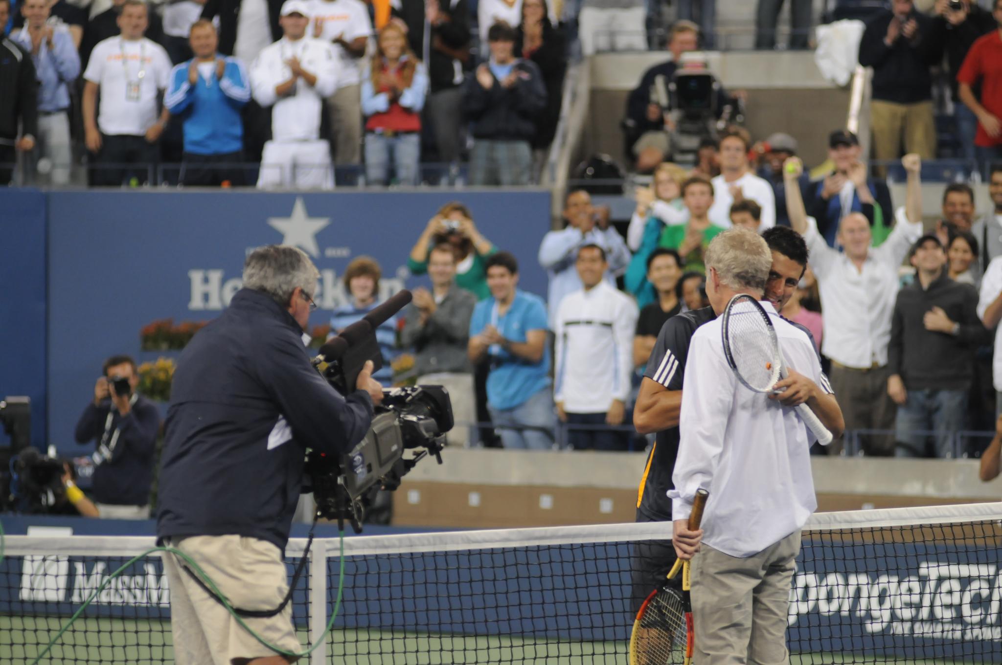 the tennis player and a cameraman talk to the media