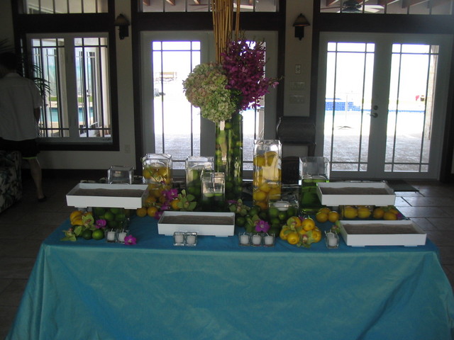 the table has fruits and flowers in each section