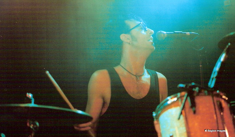a man is playing drums and a mic