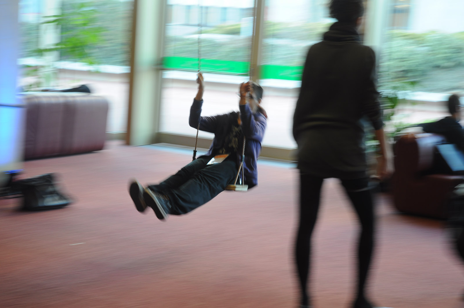 a young man is swinging in the air by a female