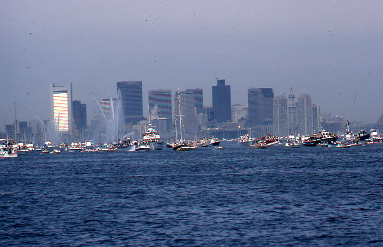 the ships are lined up in the harbor with city buildings in the background