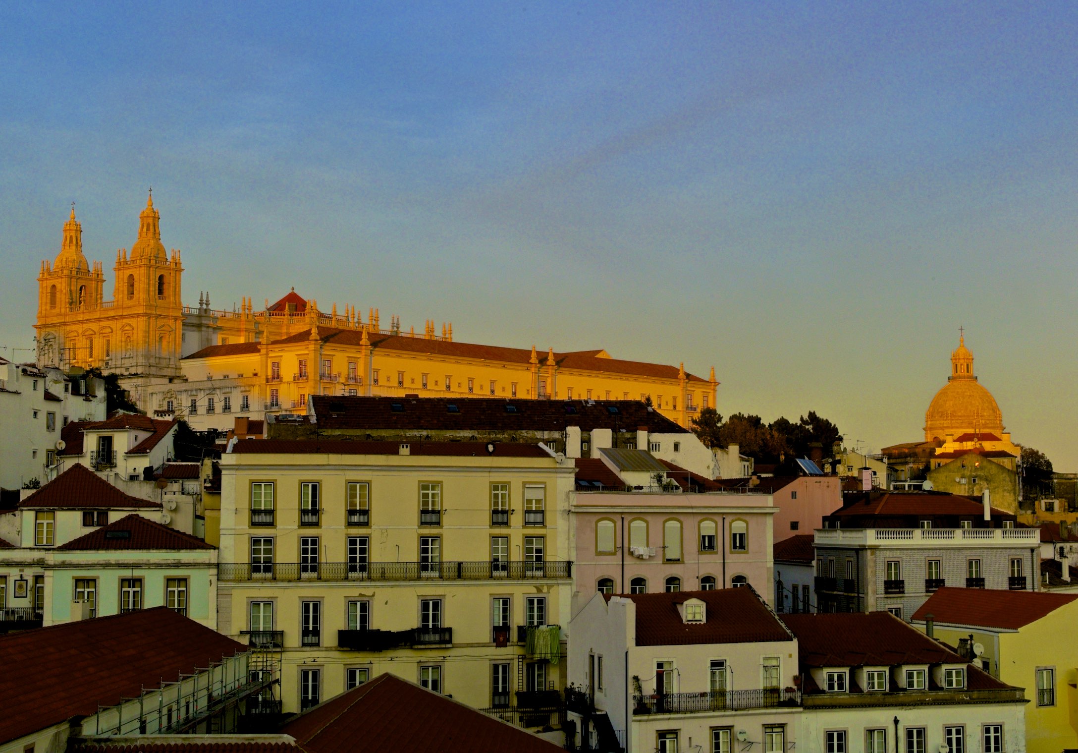 a big yellow building in front of some other buildings