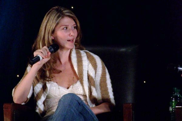 a woman sitting on top of a chair holding a microphone