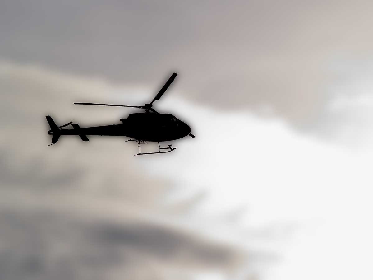 black and white po of a helicopter flying through the sky