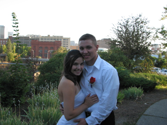 a smiling couple emce each other while posing for a picture in the city