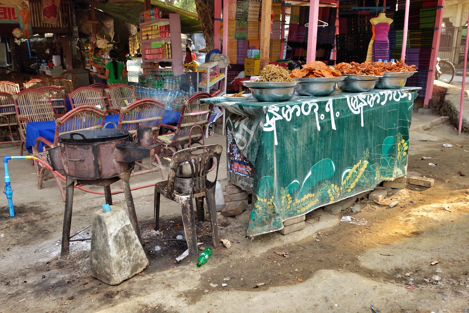 a fruit stand in a market with various chairs