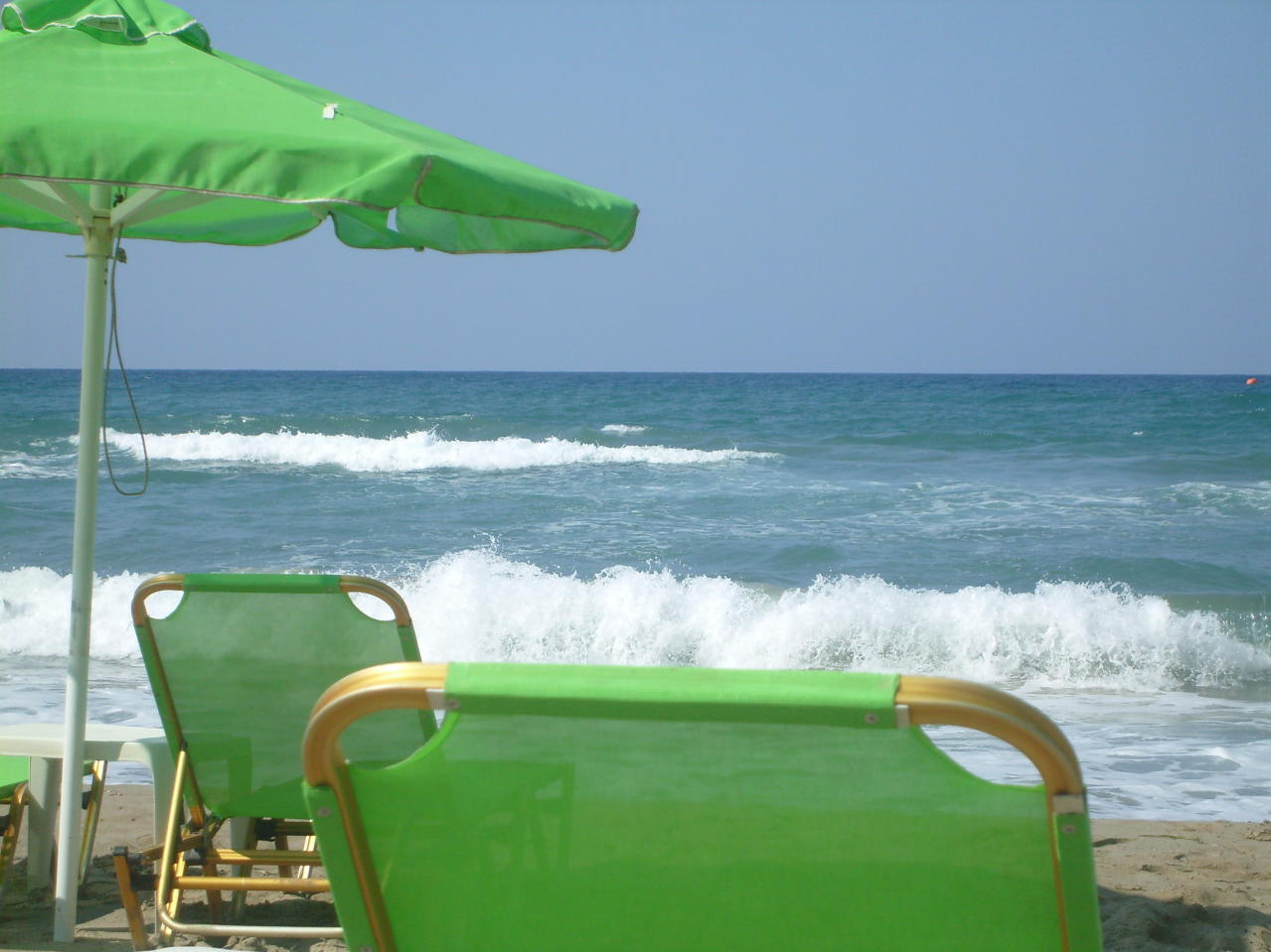 some chairs and umbrellas by the water