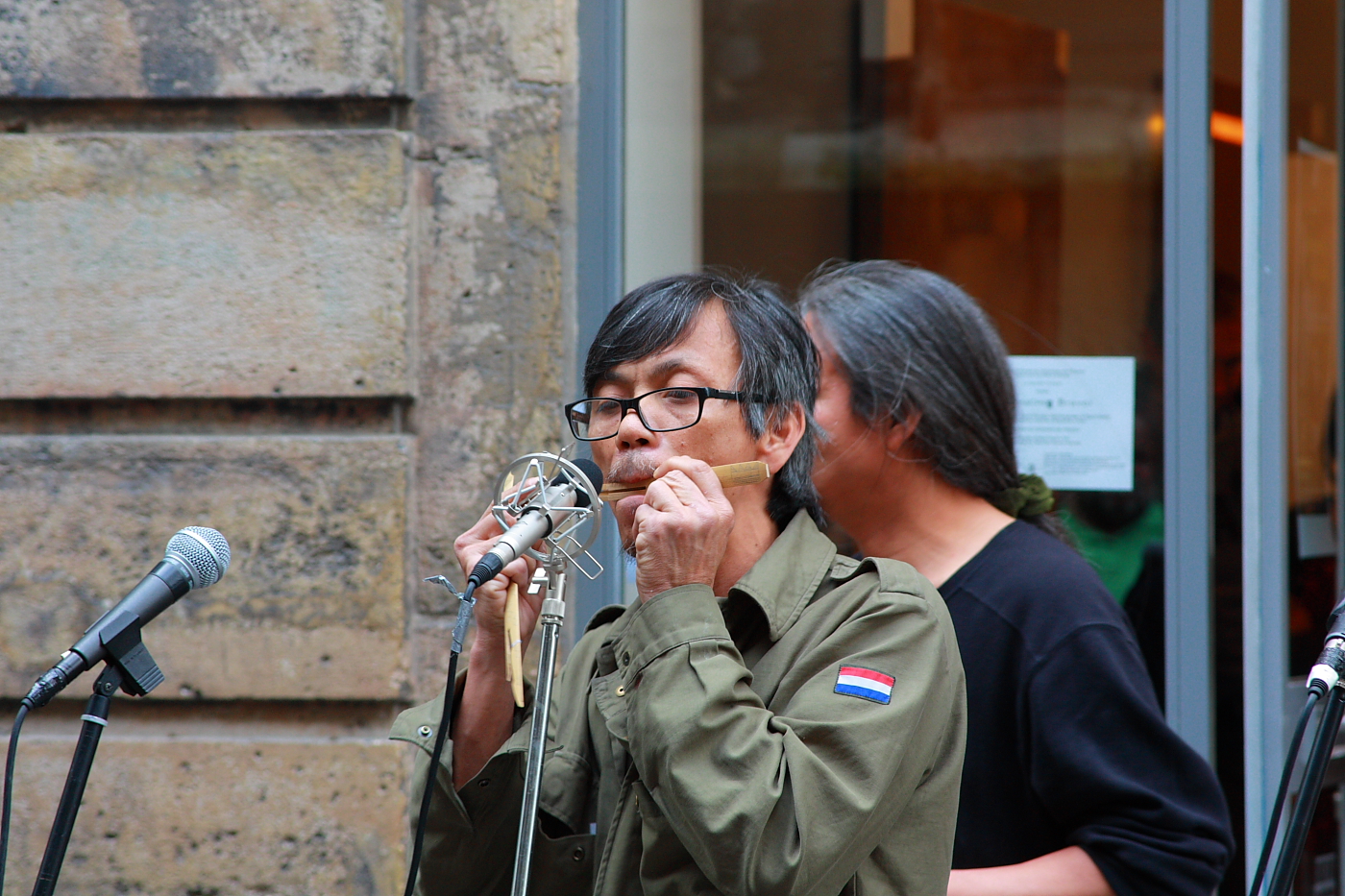 two people are standing outside in front of a microphone