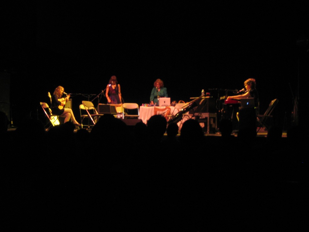 group of people sitting on stage performing a musical piece