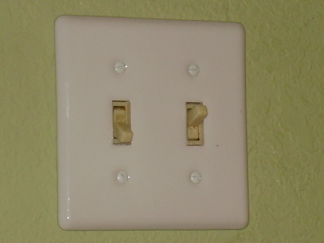 a white light switch that has been taken apart