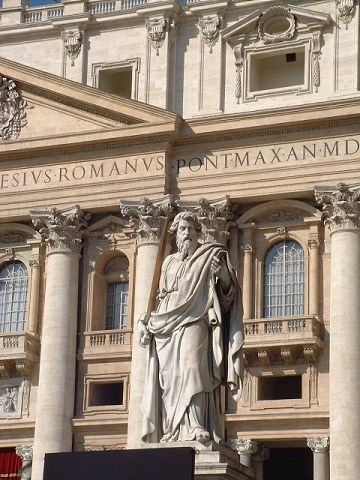a statue of jesus next to the front of an ornate building
