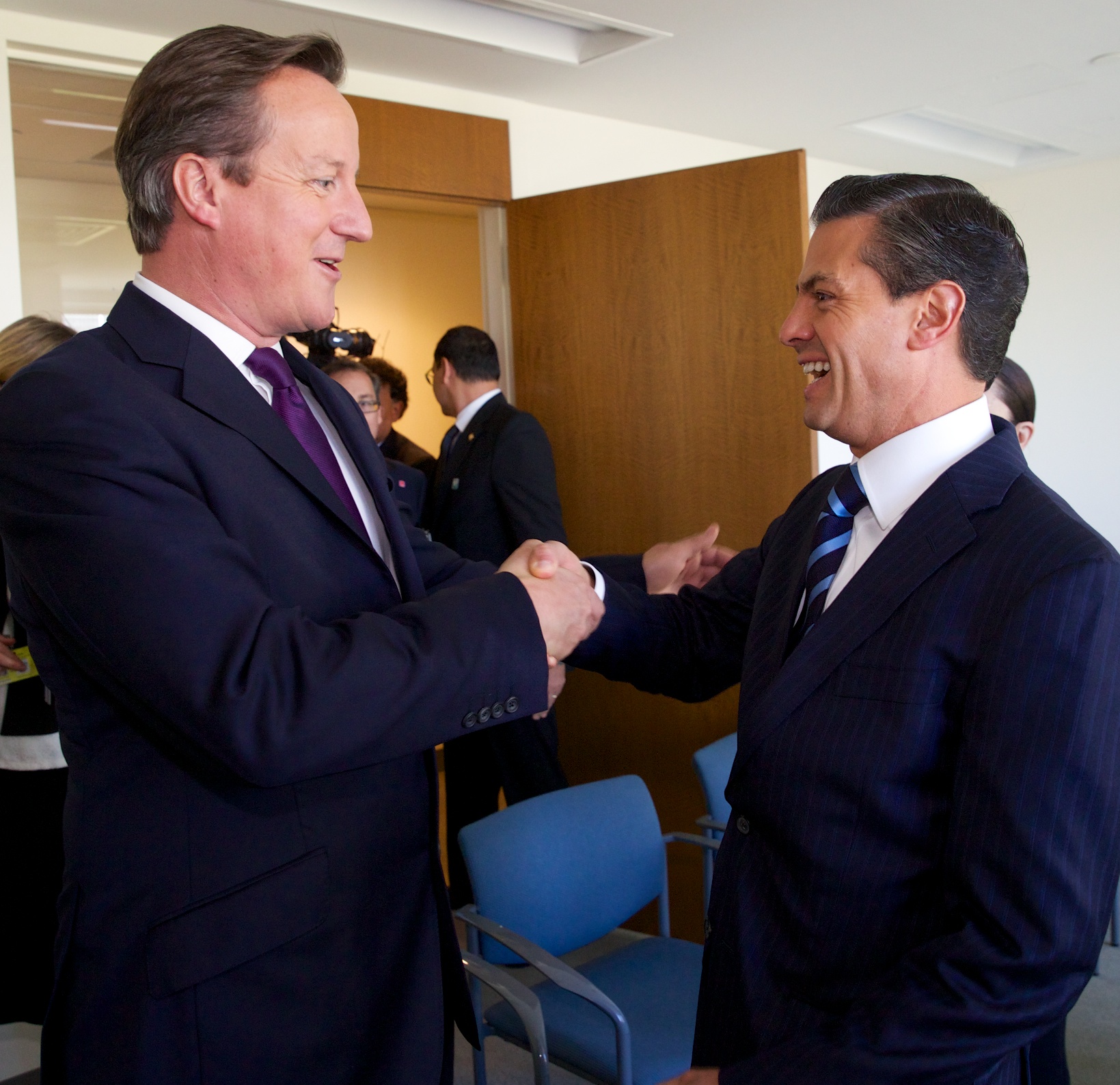 two businessmen are in suits standing next to each other